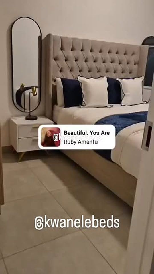 Bedroom with a grey wingback tufted headboard and pedestal